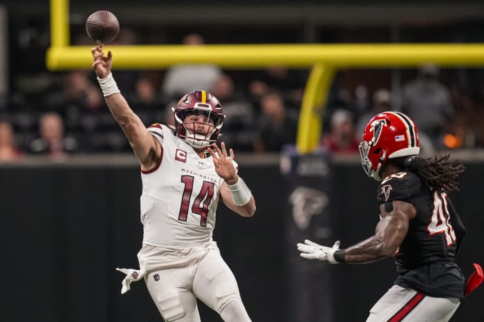 Washington Commanders quarterback Sam Howell (14) passes over Atlanta Falcons linebacker Bud Dupree (48) during the first quarter at Mercedes-Benz Stadium.